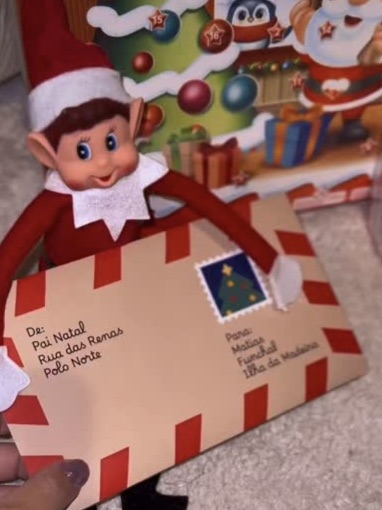 Elfo de Natal a segurar o envelope de uma carta do Pai Natal