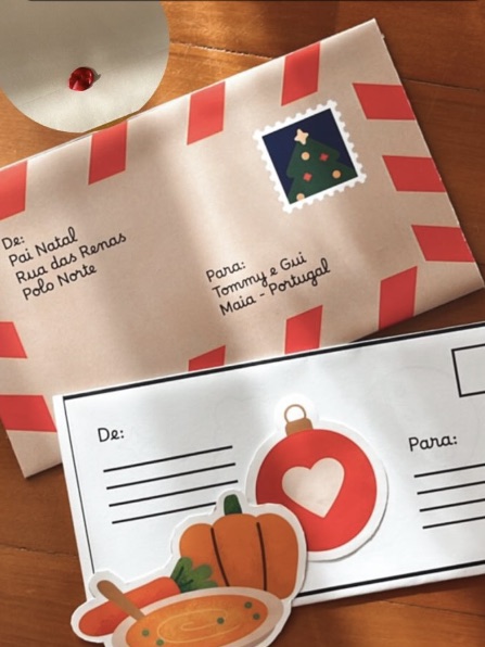 Envelope da carta do Pai Natal ao lado de um postal de Natal