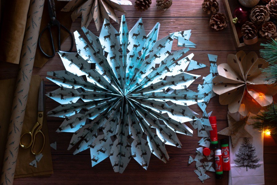 Estrela de papel feita à mão, com tesoura e materiais de trabalhos manuais