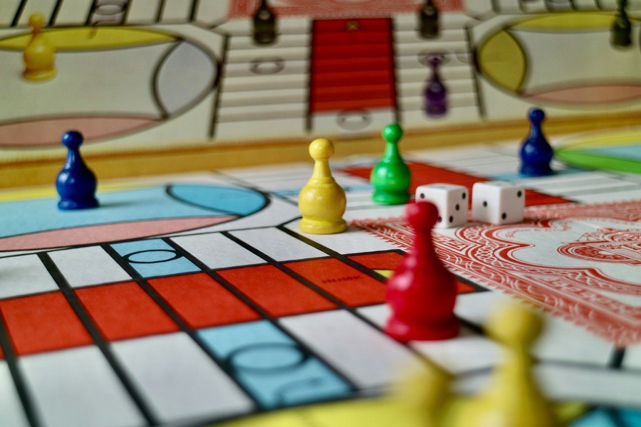 Tabuleiro de jogo com peões e dados, para jogar em família